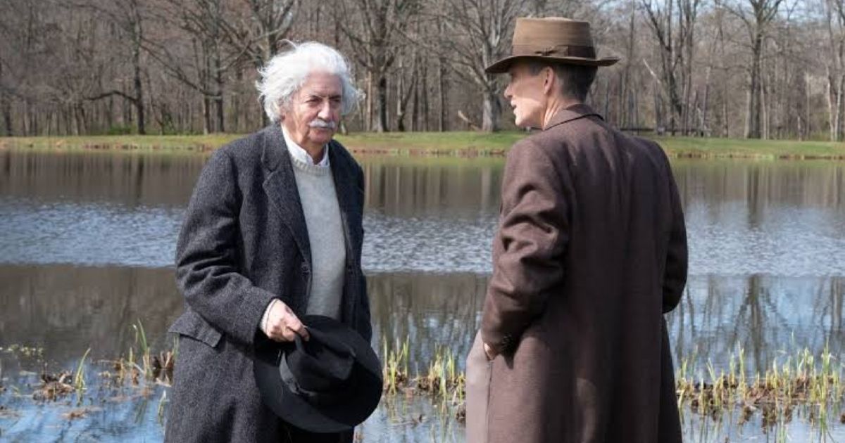 Einstein chats with oppenheimer in an open field in film Oppenheimer 