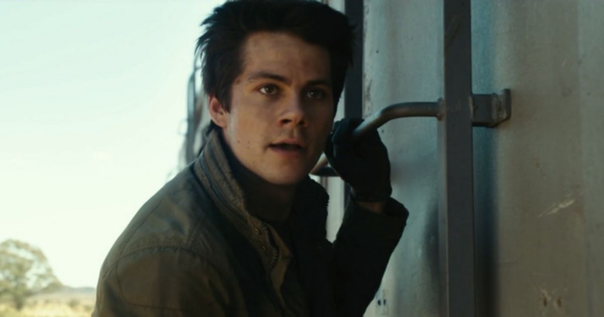 Dylan O'Brien as Thomas holding onto the side of a train