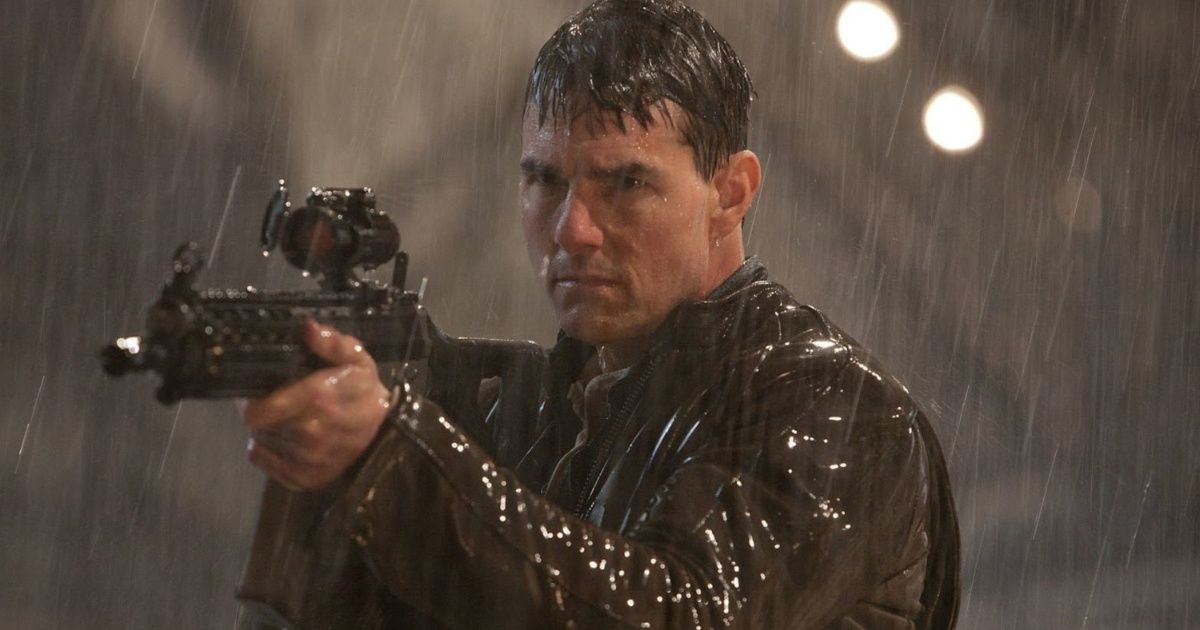 Tom Cruise in a rain shootout scene in Jack Reacher: Never Go Back, holding a rifle and pointing it at someone.