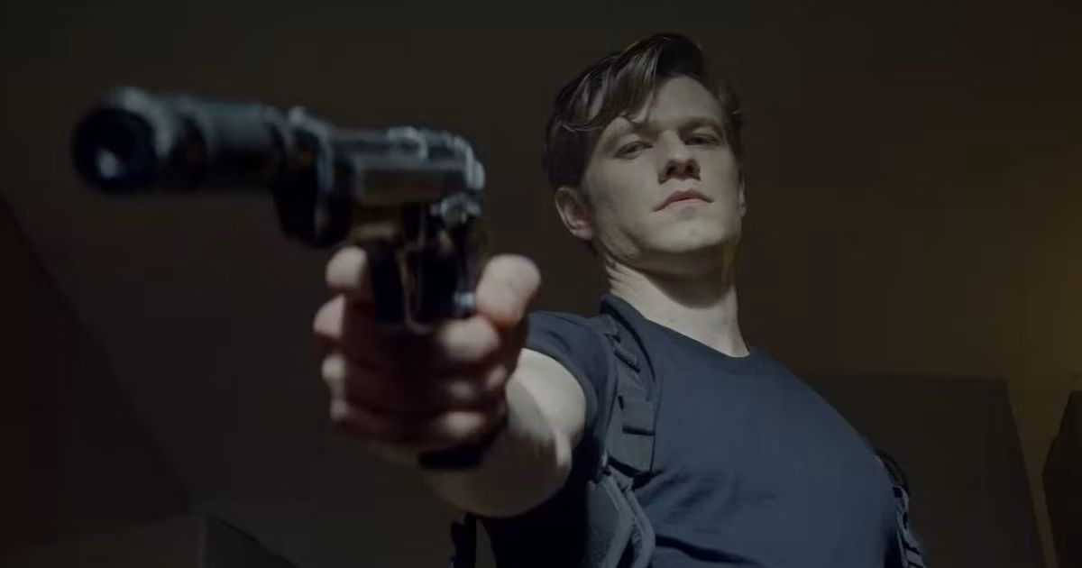 Lucas Till holds a gun in The Collective action movie
