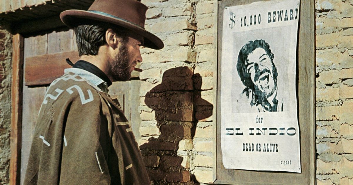 Bounty hunter Clint Eastwood looks at a wanted poster in the Western movie For a Few Dollars More