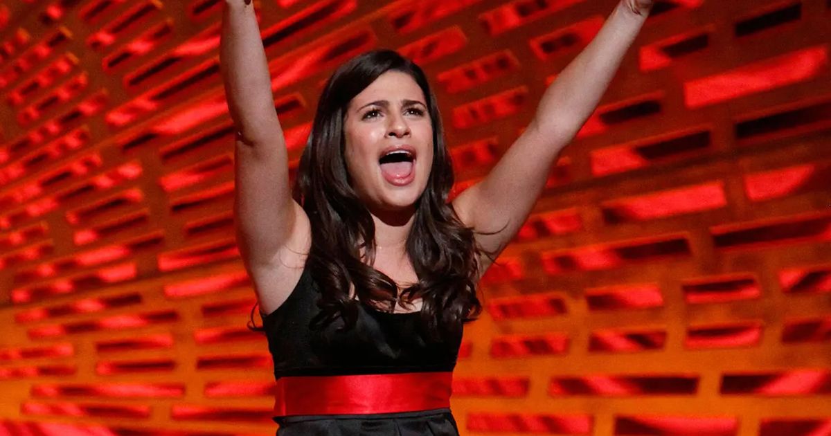 Rachel sings and lifts her arms in Glee