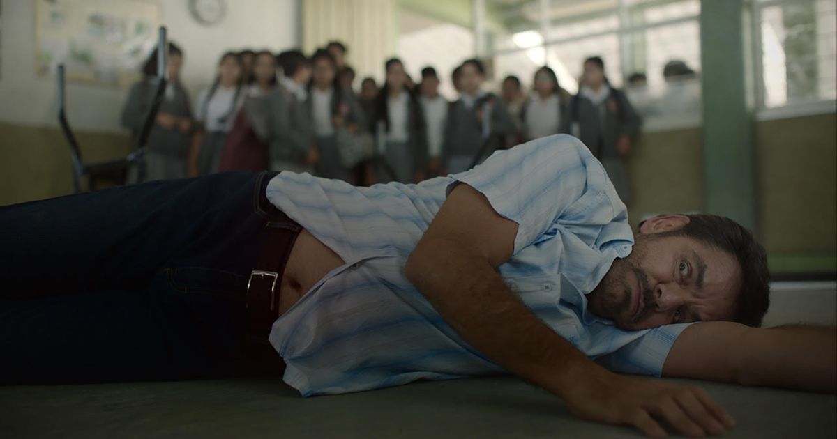 Eugenio Derbez lying on the ground with his students behind him in Radical (2023)