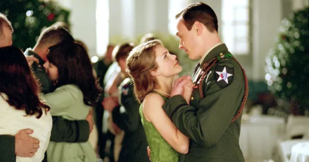 Kerry Russell as Barbara Geoghegan and Chris Klein as 2nd Lt. Jack Geoghegan in his military uniform with patches on it, as the couple dance in a crowded ballroom in We Were Soldiers