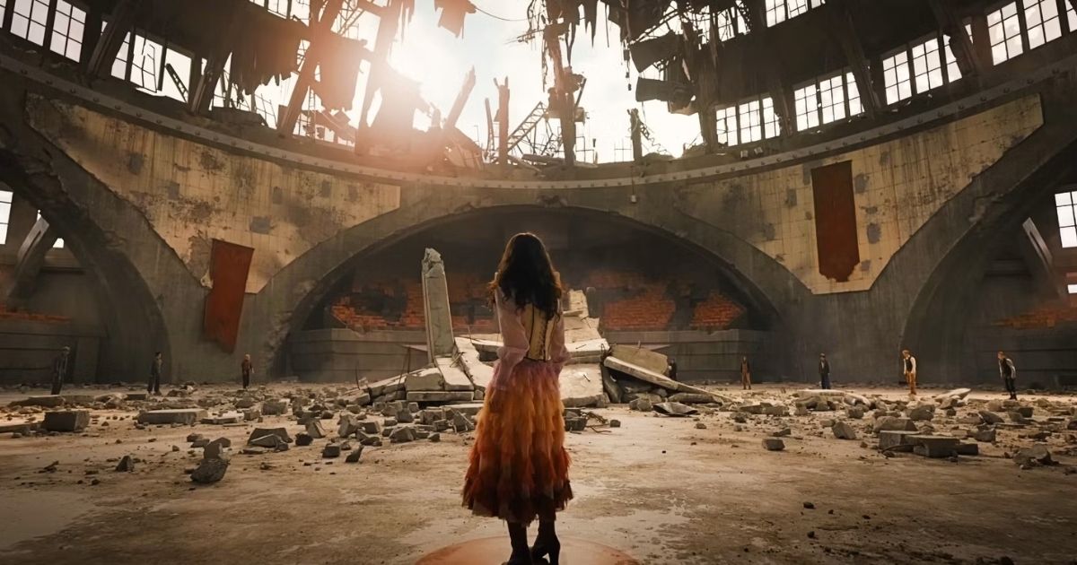 Rachel Zegler as Lucy Gray Baird standing in a broken dome arena for The Hunger Games in The Hunger Games: The Ballad of Songbirds and Snakes (2023)