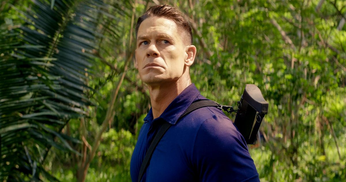 John Cena in Freelance with a gun slung over his back while he stands in the jungle.
