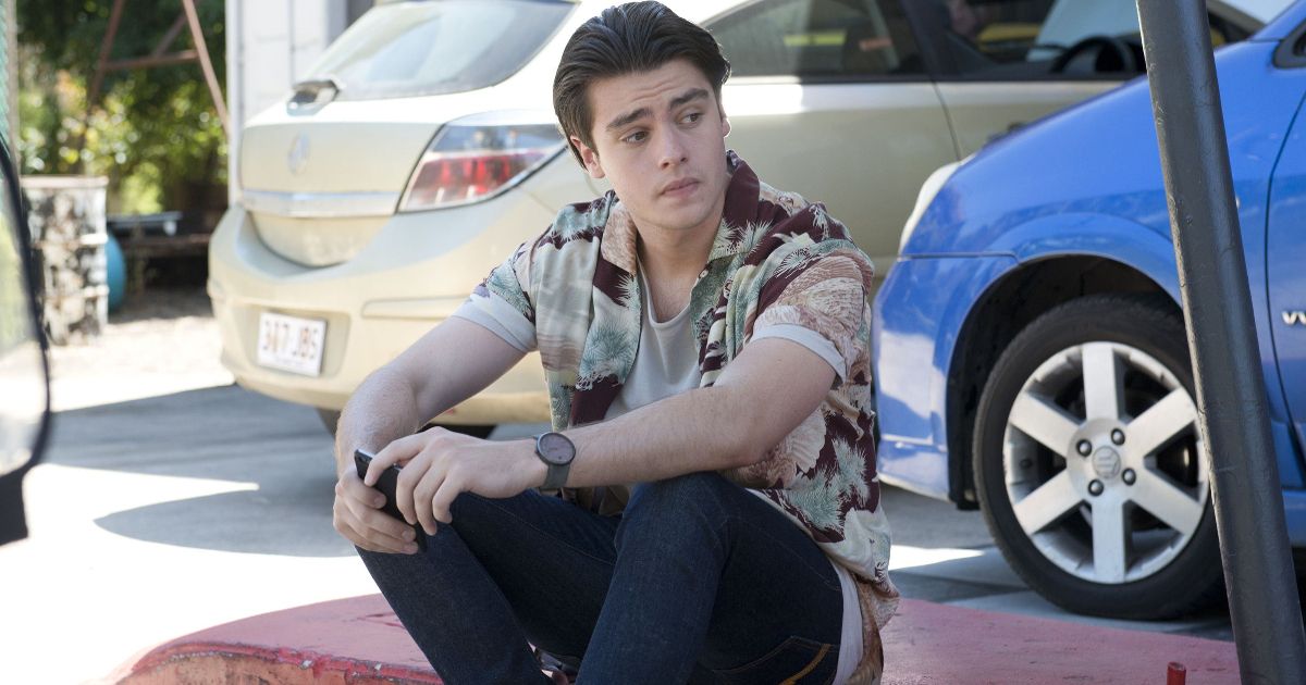 Ben sits on a car in Neighbours