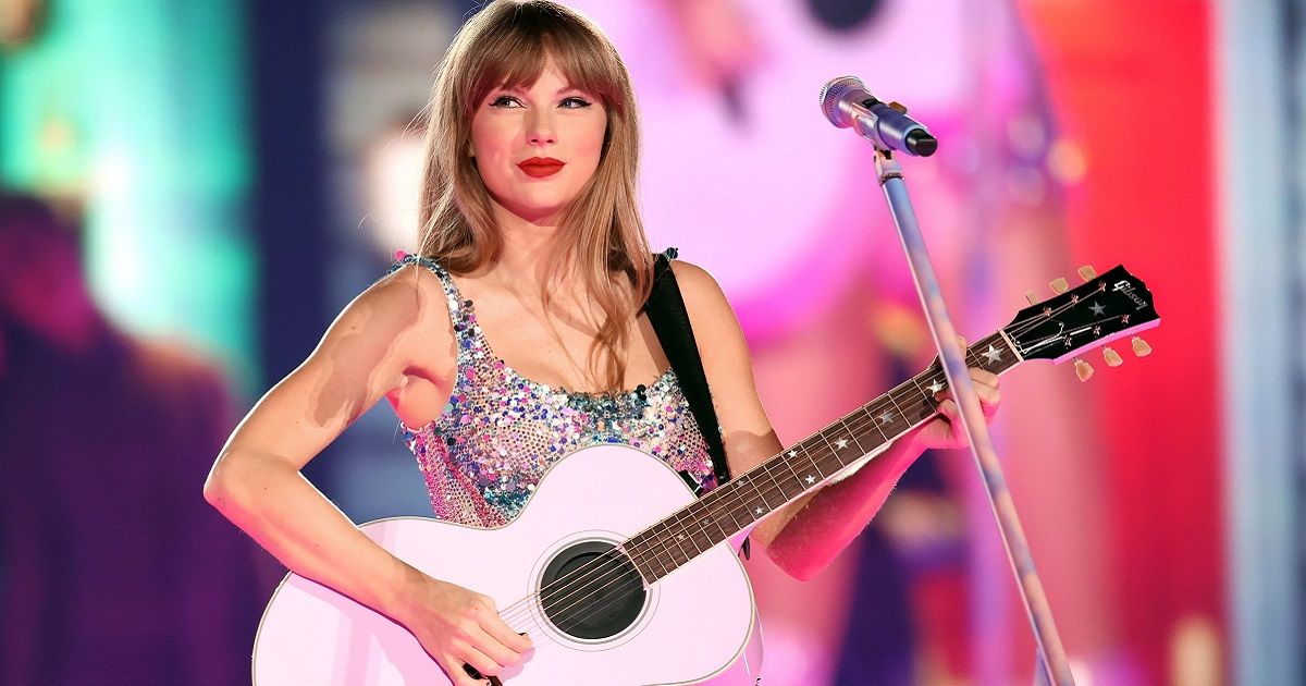 Taylor Swift onstage with her guitar in a sparkle dress.