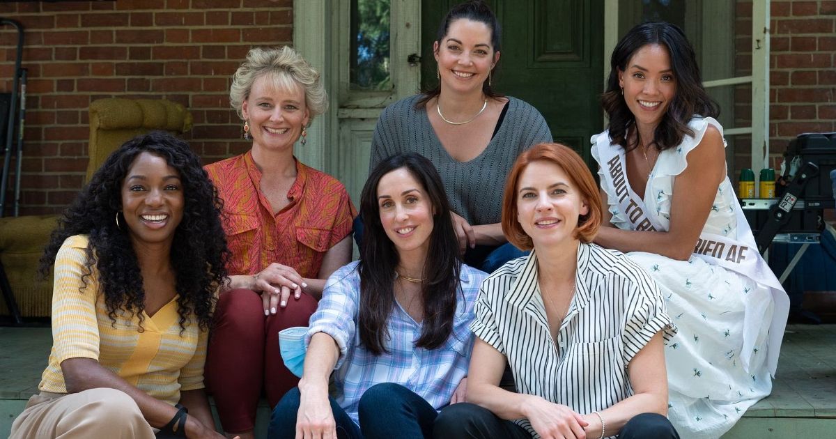 The cast of Workin Moms poses together on the patio