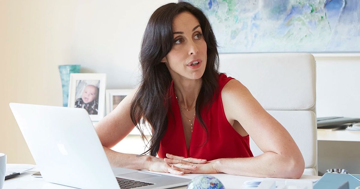 Kate sits at her desk in Workin' Moms