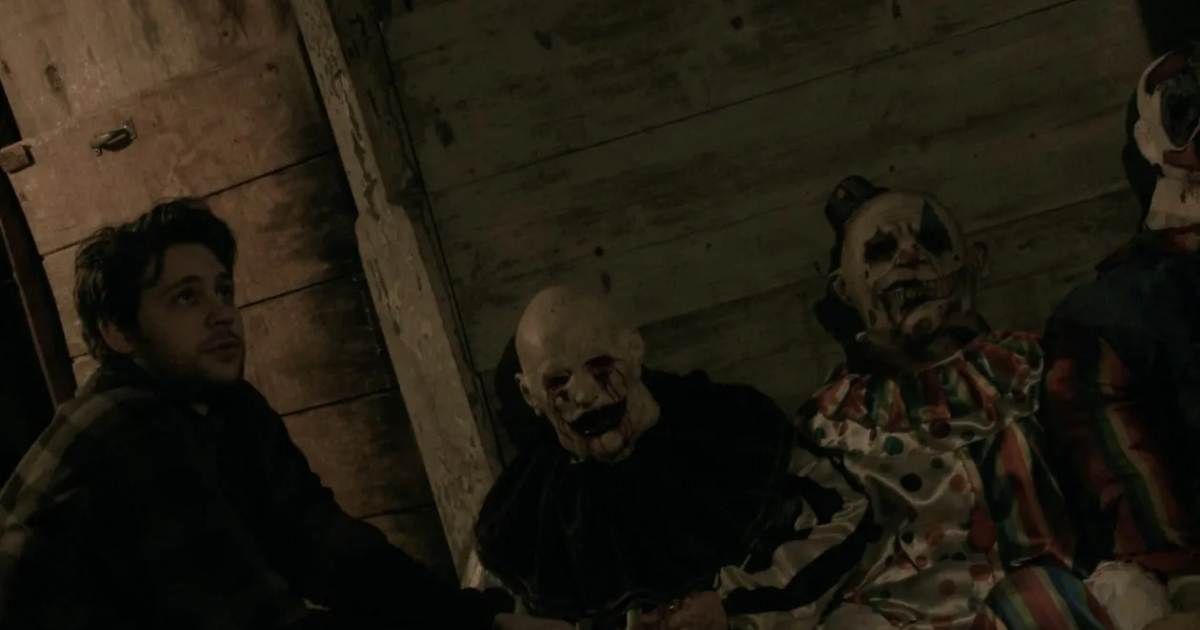 A young victim crouches beside clowns in Hell House LLC