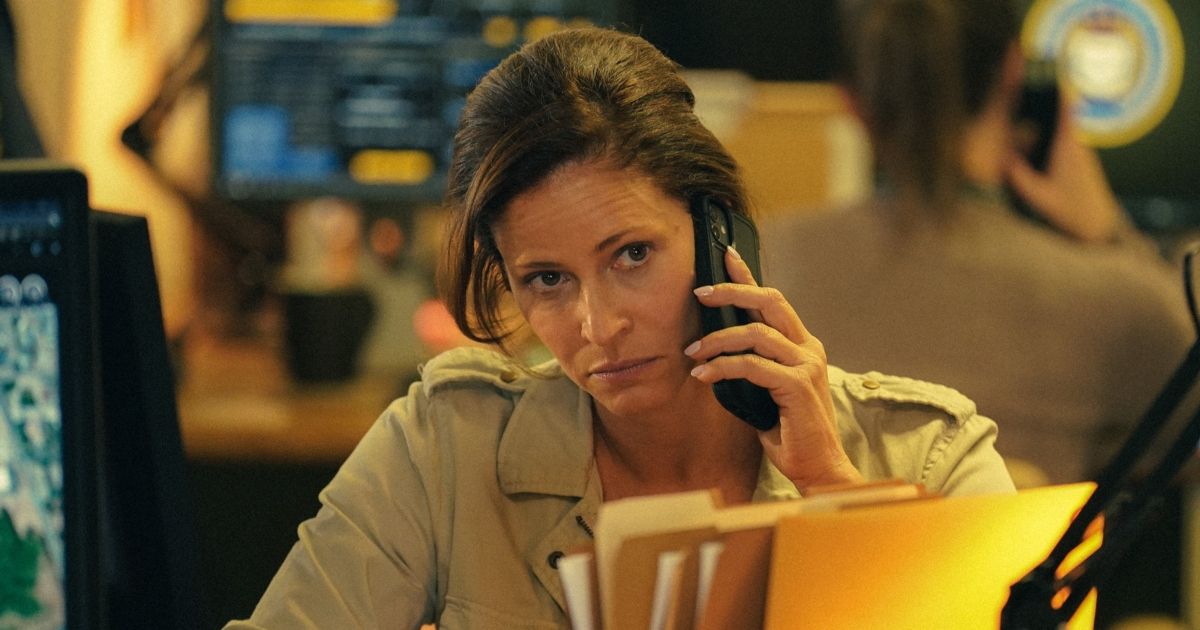 Andrea Savage on the phone at a desk at work in Tulsa King