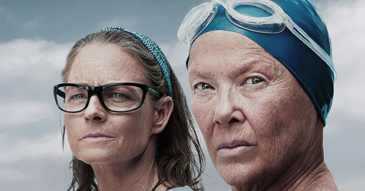 Annette Bening wearing a swim cap and goggles and Jodie Foster next to her in Nyad
