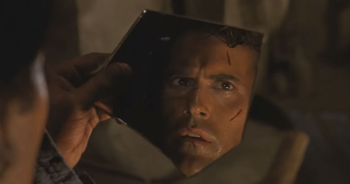 Ash Williams (Bruce Campbell) looking into a broken mirror in Army of Darkness (1992)