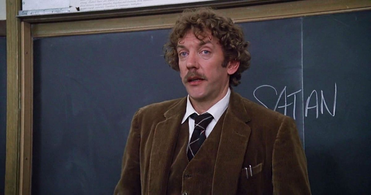 Donald Sutherland with a blackboard behind him with the word 