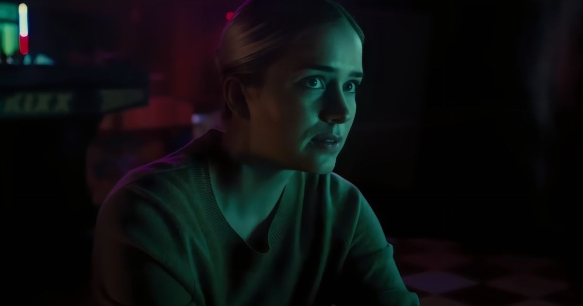 Elizabeth Lail como Vanessa em um quarto escuro com uma luz verde iluminando seu rosto em Five Nights at Freddy's.