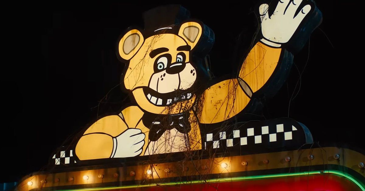Still from Five Nights at Freddy's with Freddy Fazbear waving to customers from a sign on top of the restaurant.