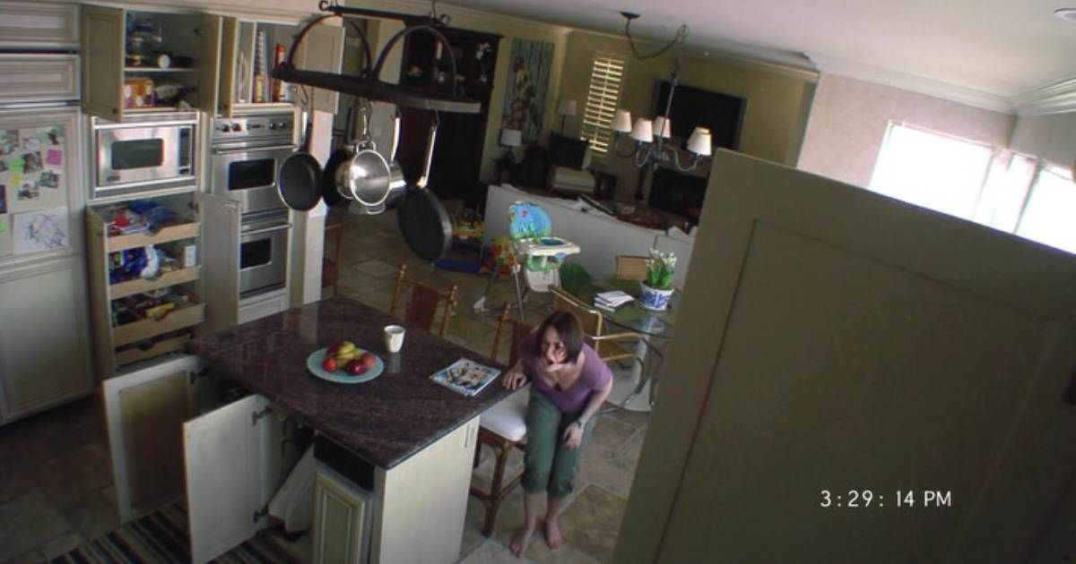 Footage still of a woman screaming in a kitchen in paranormal activity 2