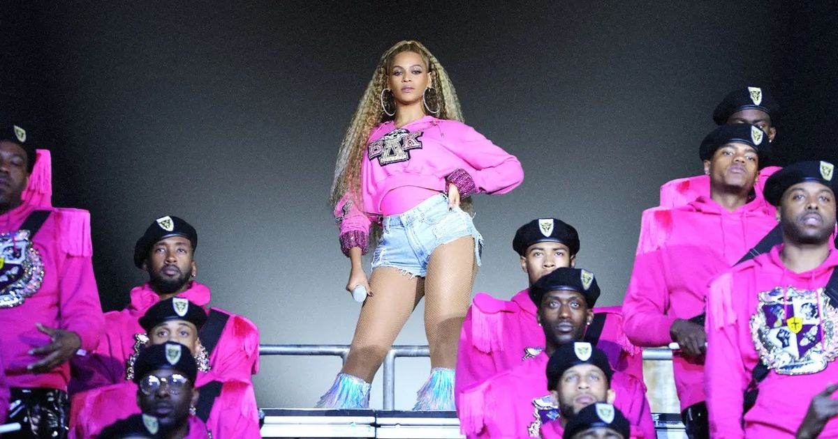 Beyoncé surrounded by fellow performers in pink in Homecoming: A Film by Beyoncé.