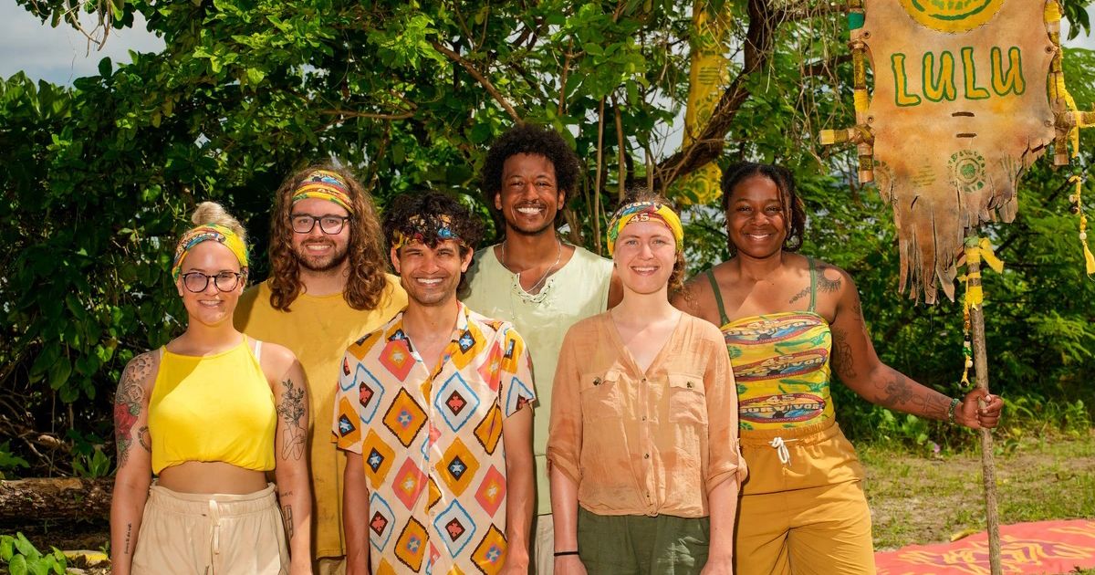 A Tribo Lulu do Survivor Season 45, todos vestindo suas roupas amarelas, posando para uma foto na praia de Fiji.