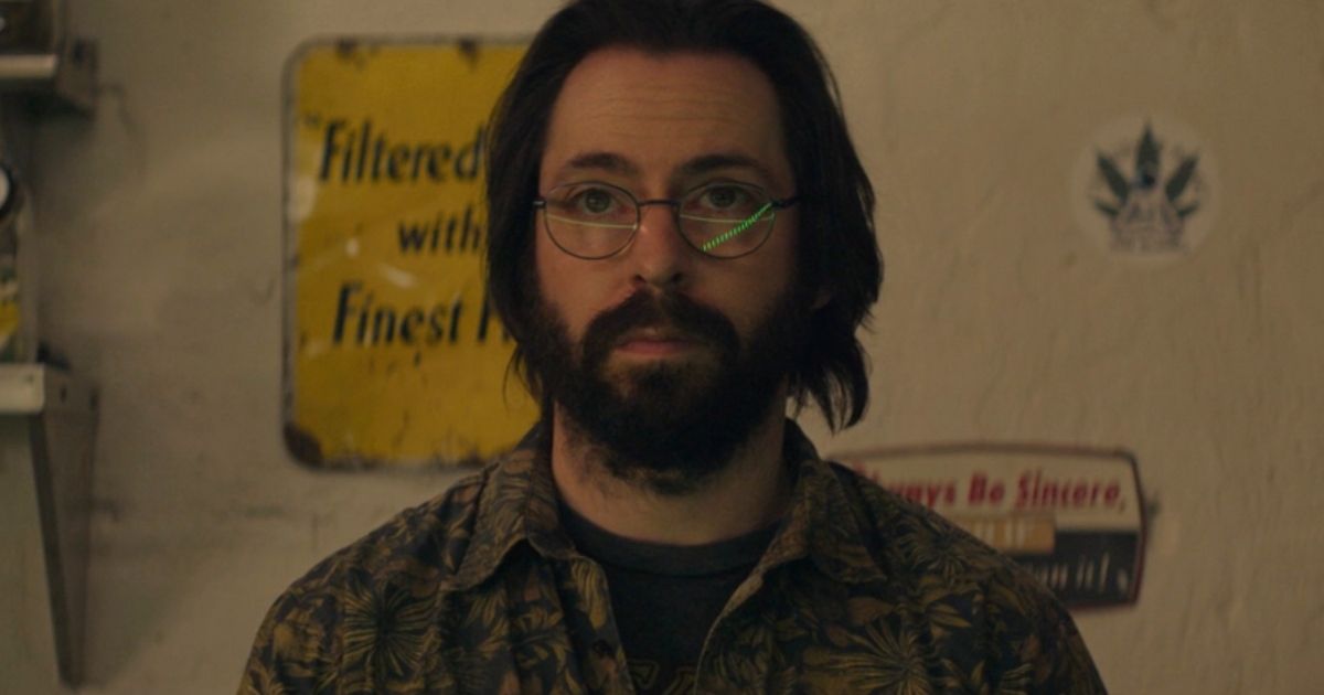 Martin Starr with several signs behind him in Tulsa King