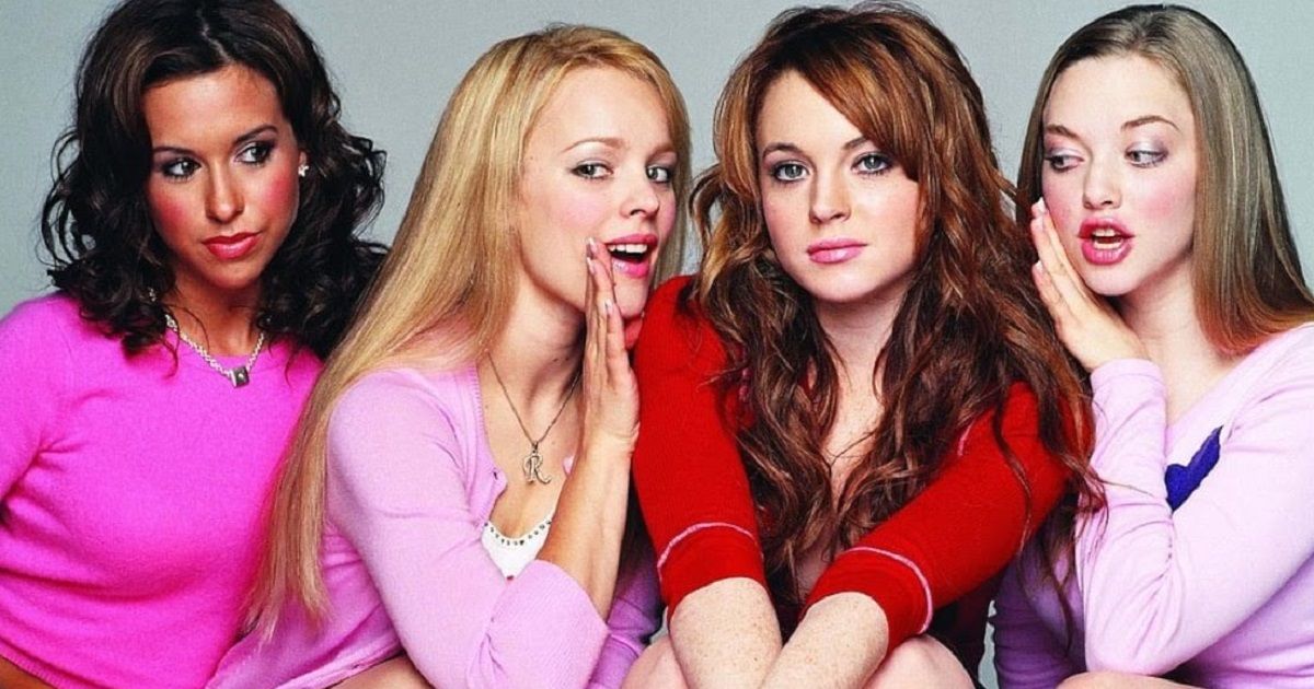 The cast of mean girls whisper in each others ears in the Mean Girls poster.