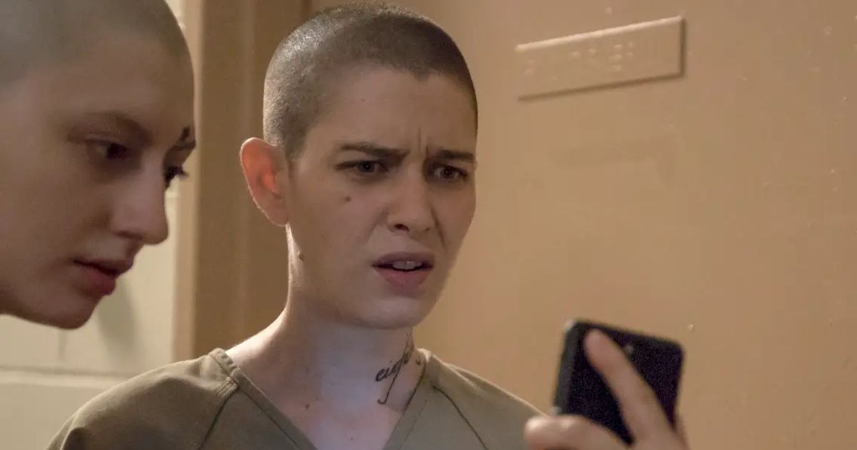 Brandy looks at a phone in Orange is the New Black