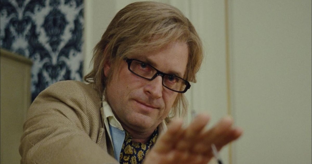 Shea Whigham wearing glasses with his hair parted in American Hustle