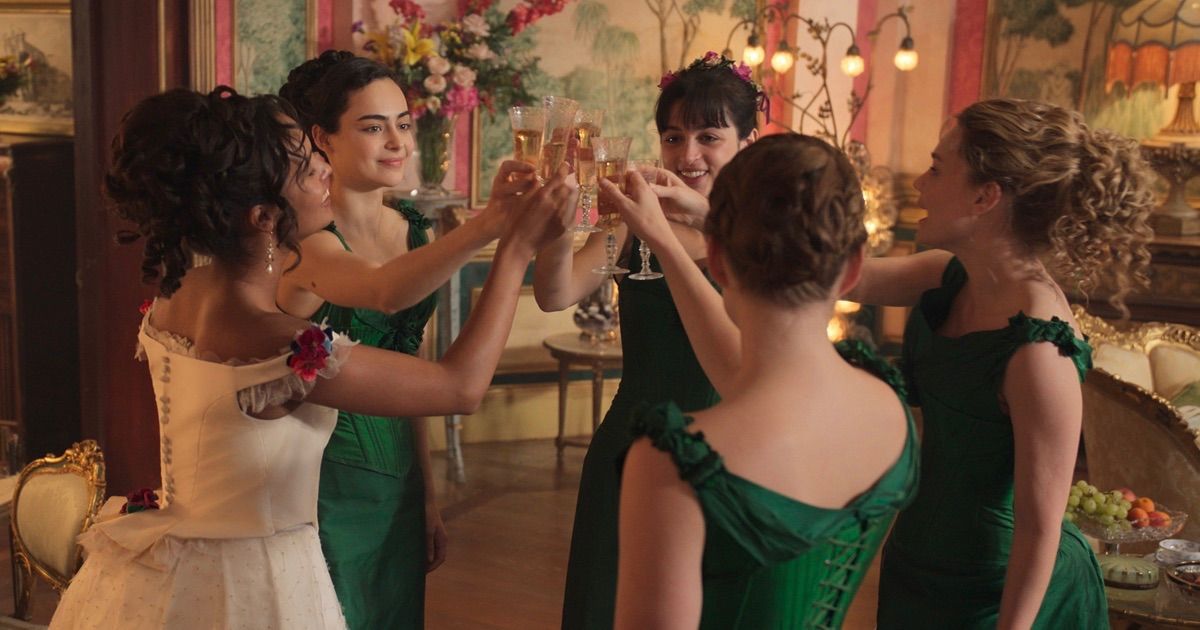 The Buccaneers apple series with four woman in green dressed and one in white toasting with champagne.