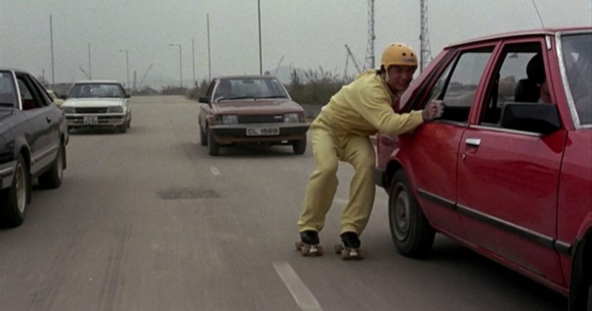 Jackie Chan roller skating in traffic in Winners & Sinners (1983)