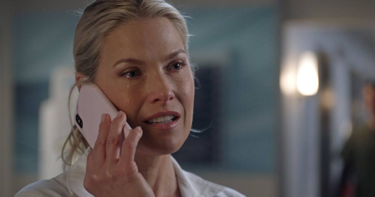 Ali Larter as Grace Sawyer in The Rookie Season 2, wearing a white shirt talking on the phone with a tear running down her eye.