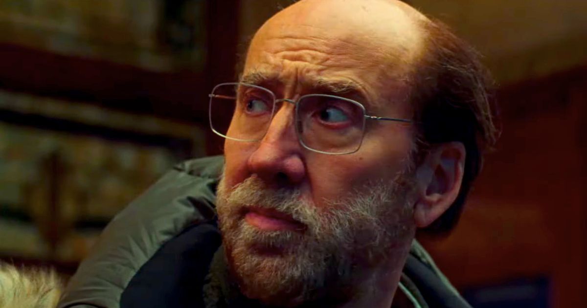 Nicolas Cage como Paul Matthews vestindo um casaco grande com capuz e óculos em Dream Scenario.
