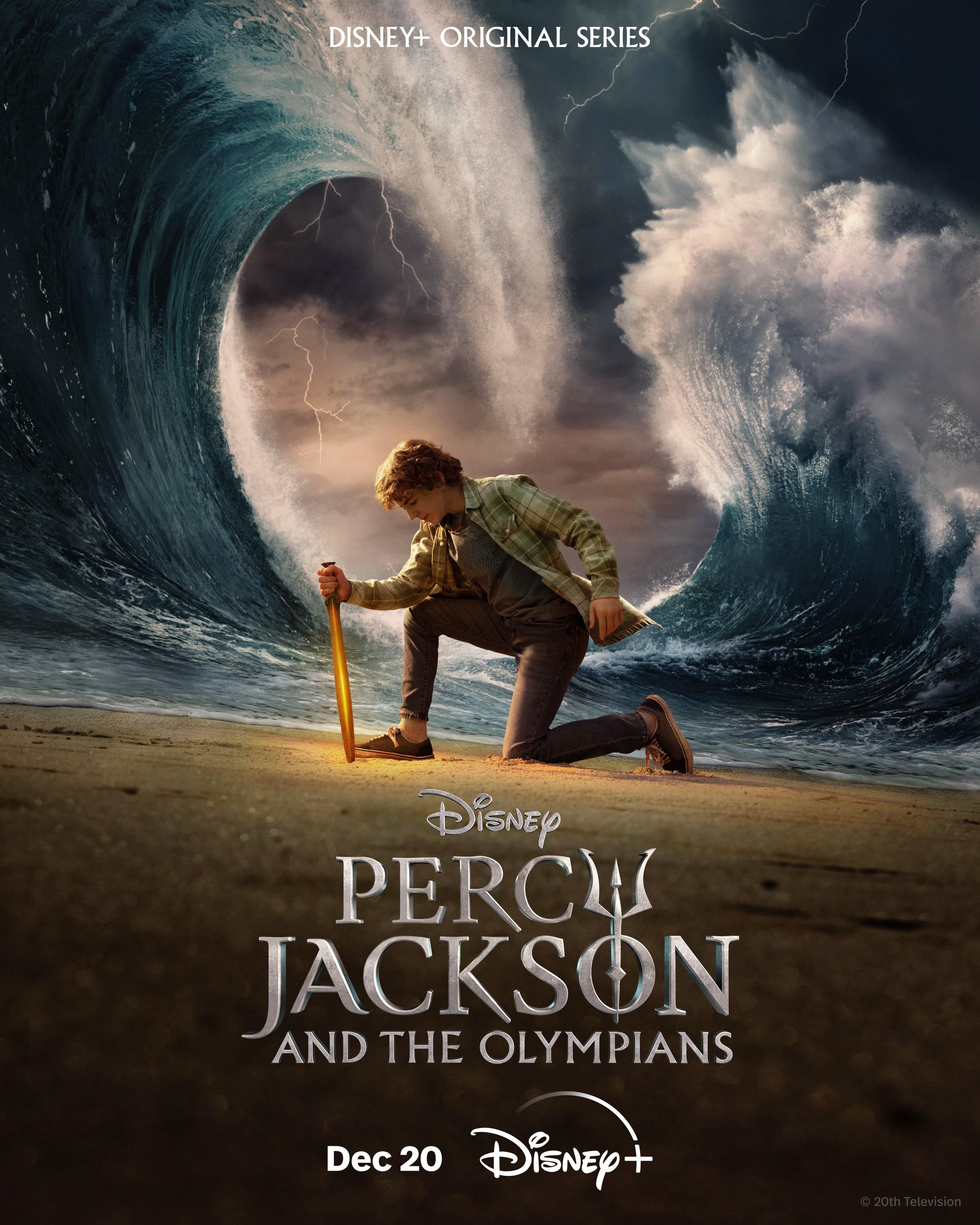 Walker Scobell as Percy Jackson, holding a blade into the sand while massive waves rise around him in a poster for Percy Jackson and the Olympians.