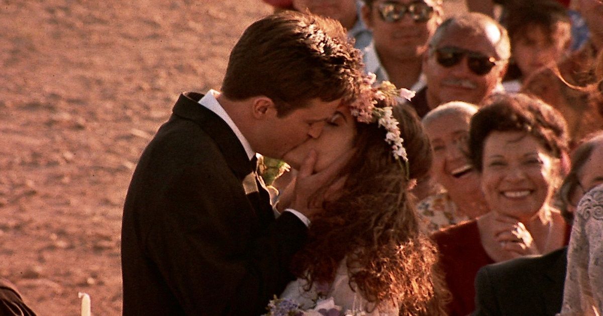 Matthew Perry and Salma Hayek share a kiss at their wedding wearing a tuxedo and wedding dress in Fools Rush In.