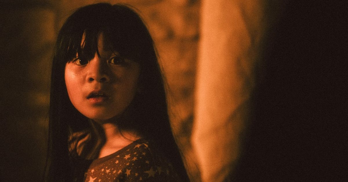 The little girl stares off in fear in a shot from Raging Grace