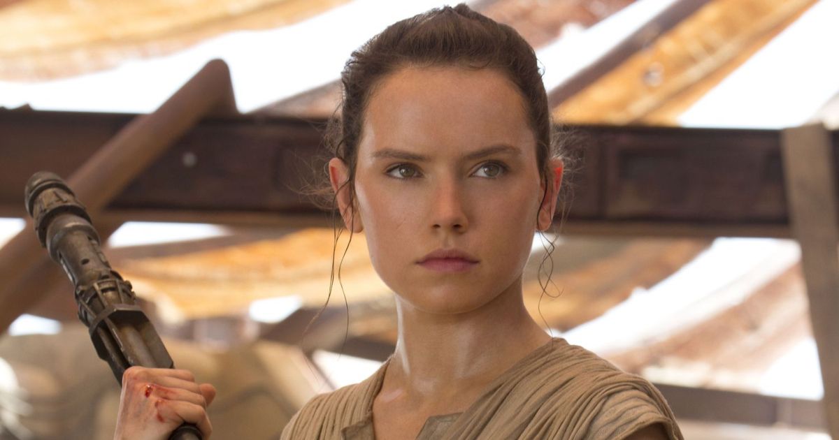 Daisy Ridley as Rey in Star Wars: The Force Awakens, with blood on her knuckles, carrying a large staff preparing to fight someone at a small market in the desert.