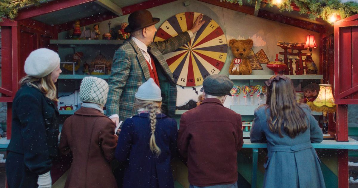 Teddy's Christmas cast at a carnival booth in winter