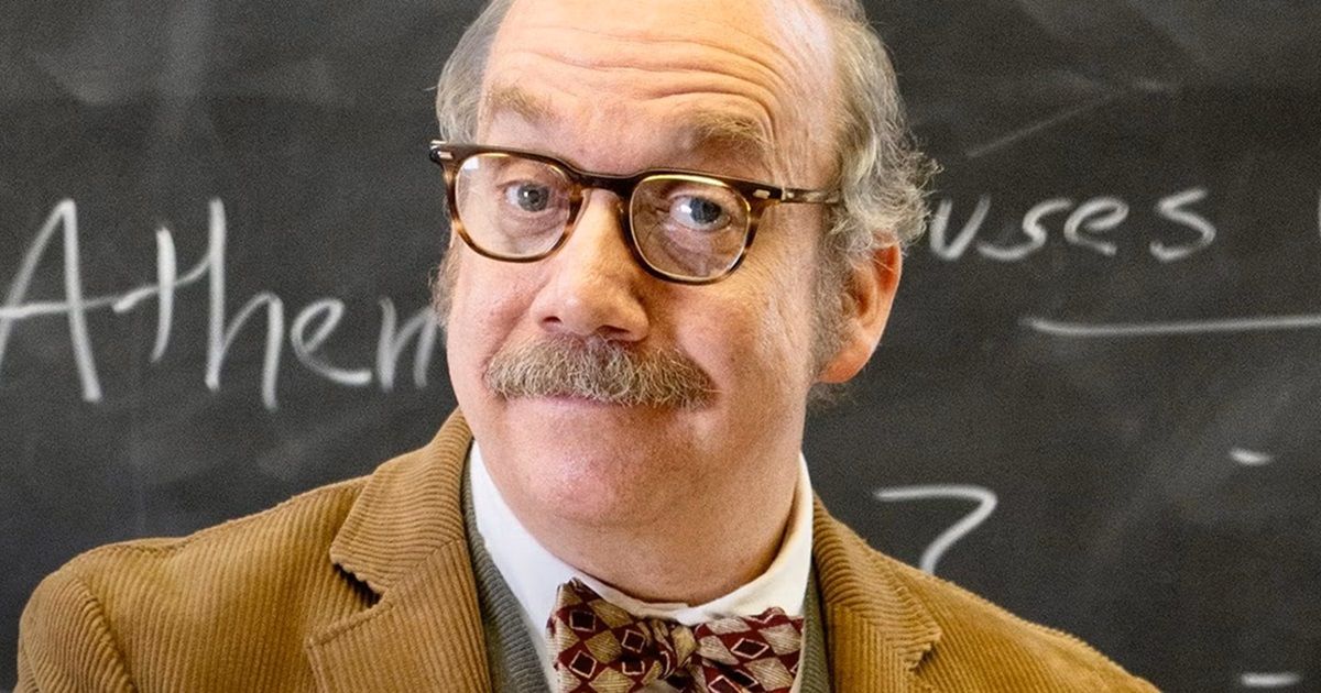 Paul Giamatti wearing a tan suit jacketm bow tie and glasses, standing in front of a whiteboard in The Holdovers.