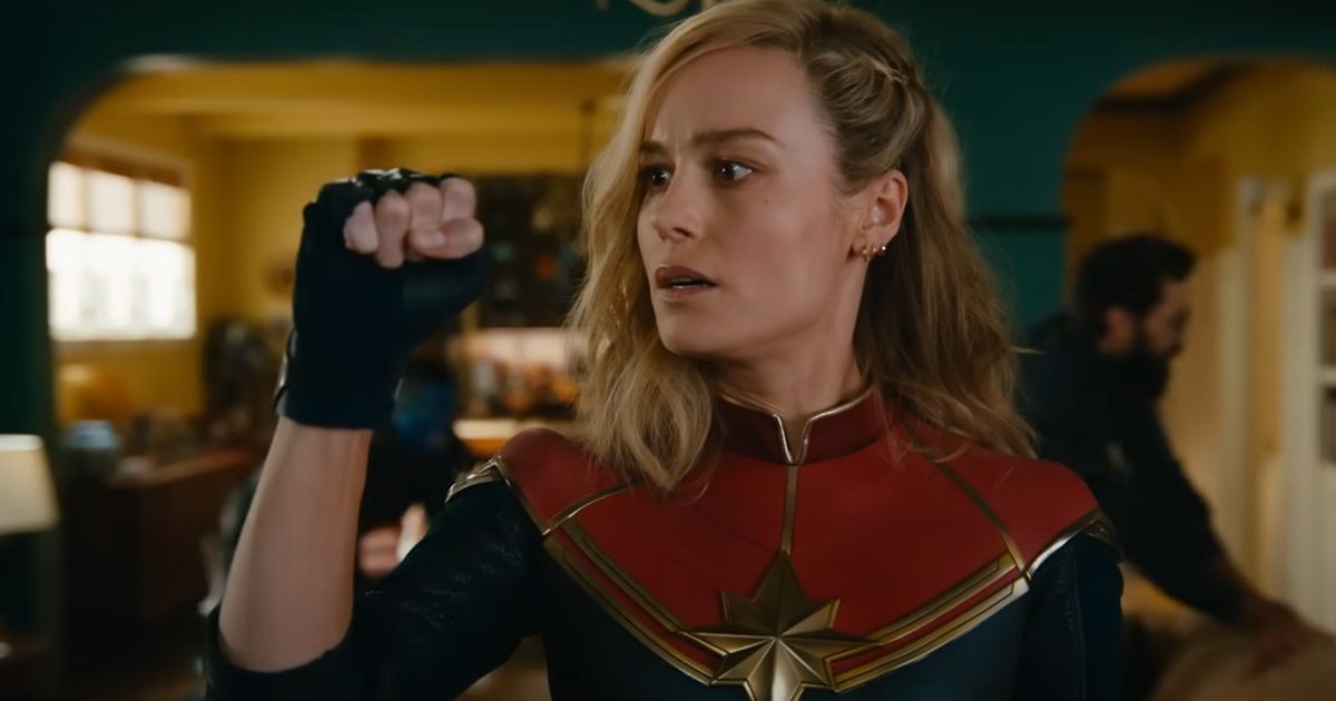 Brie Larson as Captain Marvel in a living room clinching her fist with something in The Marvels.
