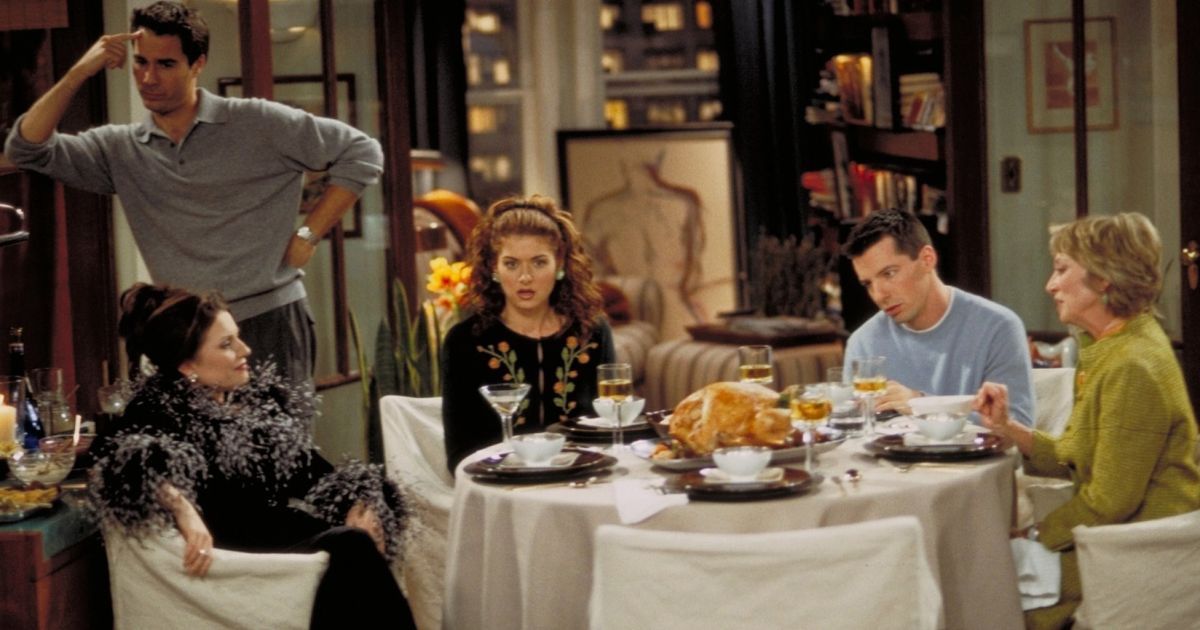 Will and Grace Homo For The Holidays the characters sit around the table about to eat a Thanksgiving meal