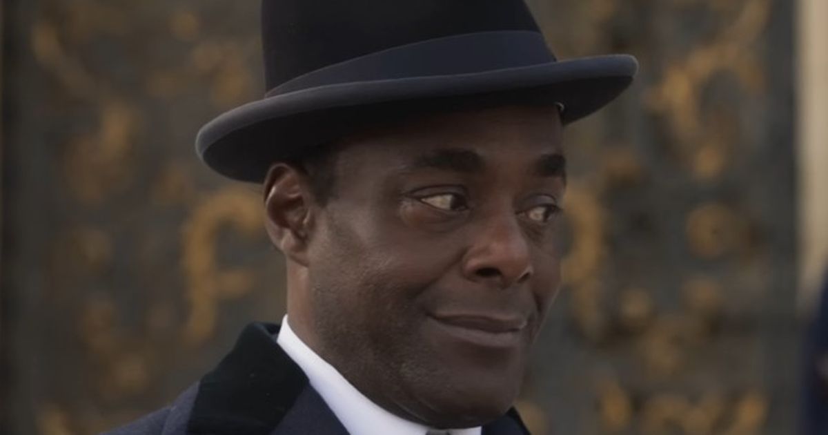 Paterson Joseph dans le rôle de Slugworth porte un chapeau de tarte au porc dans Wonka