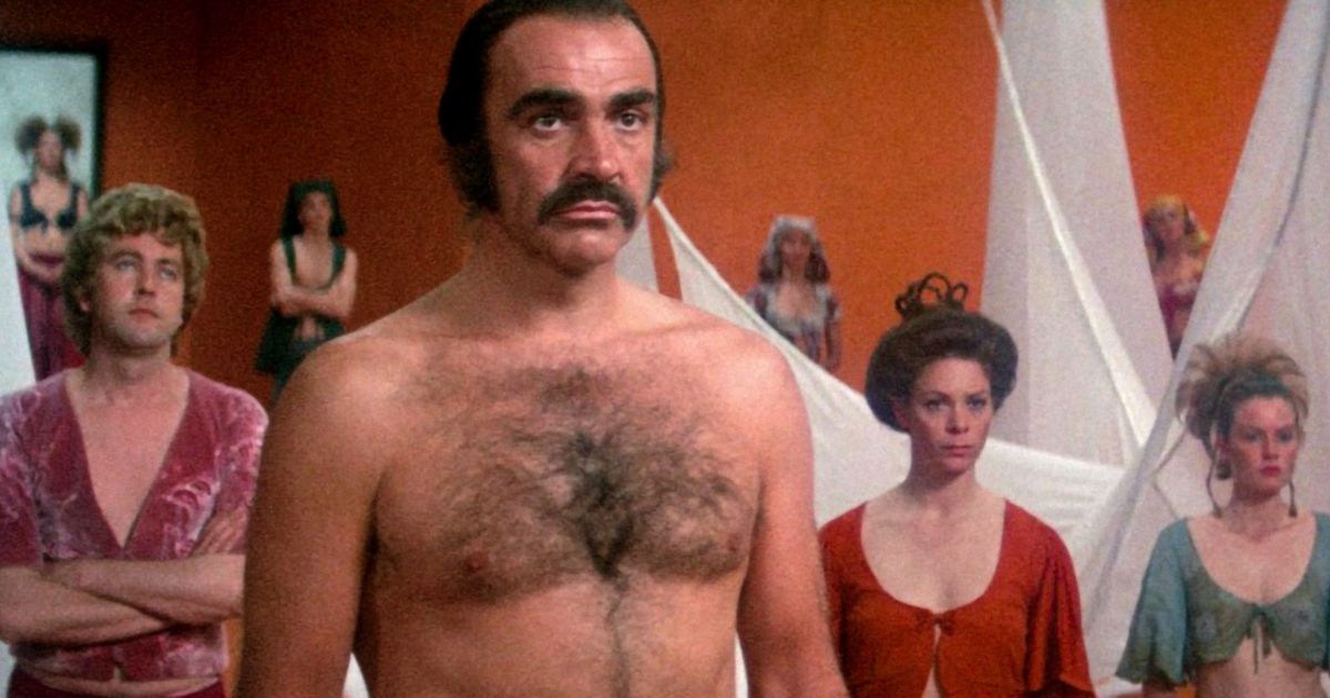 Sean Connery sem camisa com outras pessoas ao fundo em Zardoz