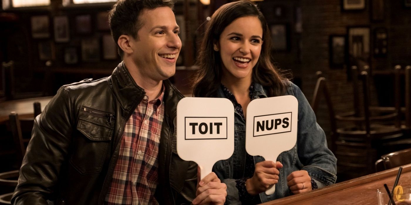 Jake and Amy holding up cards that say 'toit' and 'nups'