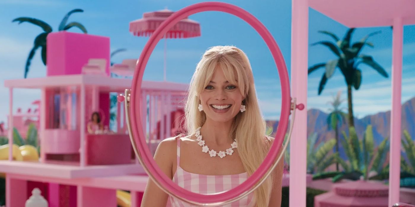 Margot Robbie as Barbie in her dreamhouse looking through a pink, round mirror in Barbie (2023).
