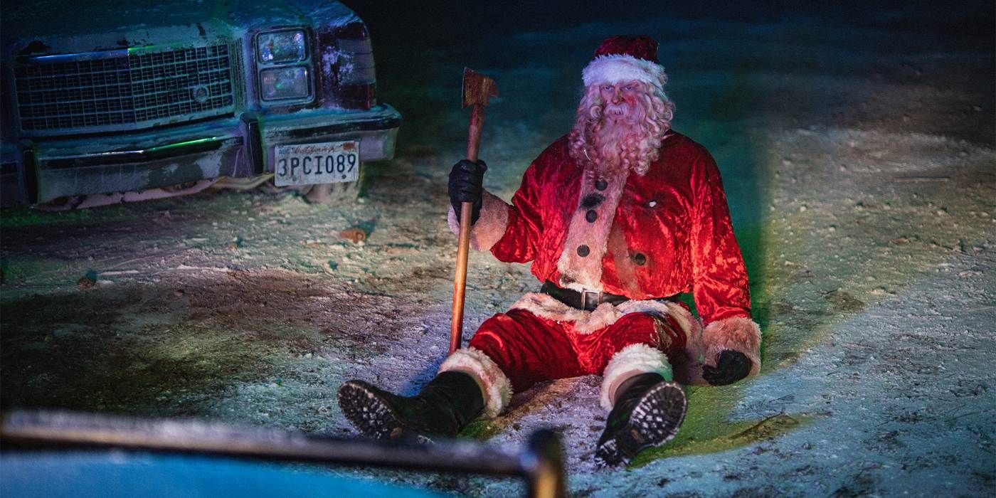 Um andróide vestido de Papai Noel sentado na neve coberto de sangue em uma foto do Natal Natal Sangrento