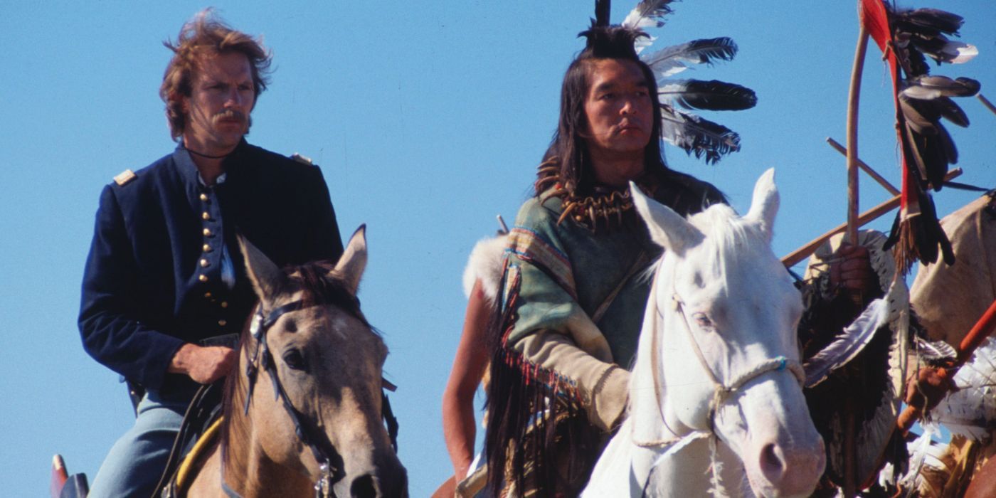 Dois homens, um branco e um indígena, sentam-se assertivamente em cavalos