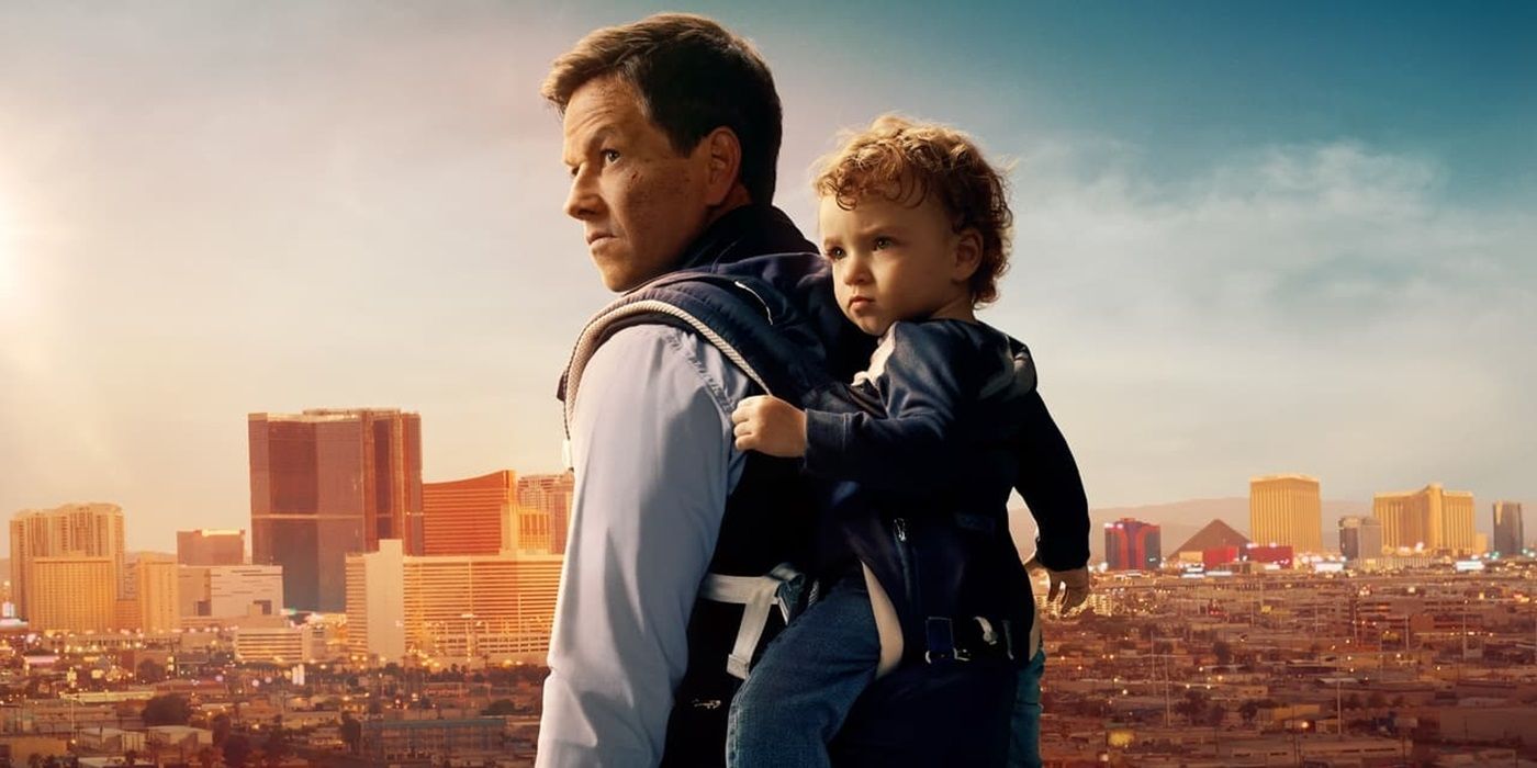 Mark Wahlberg in The Family Plan with a baby strapped to his back.