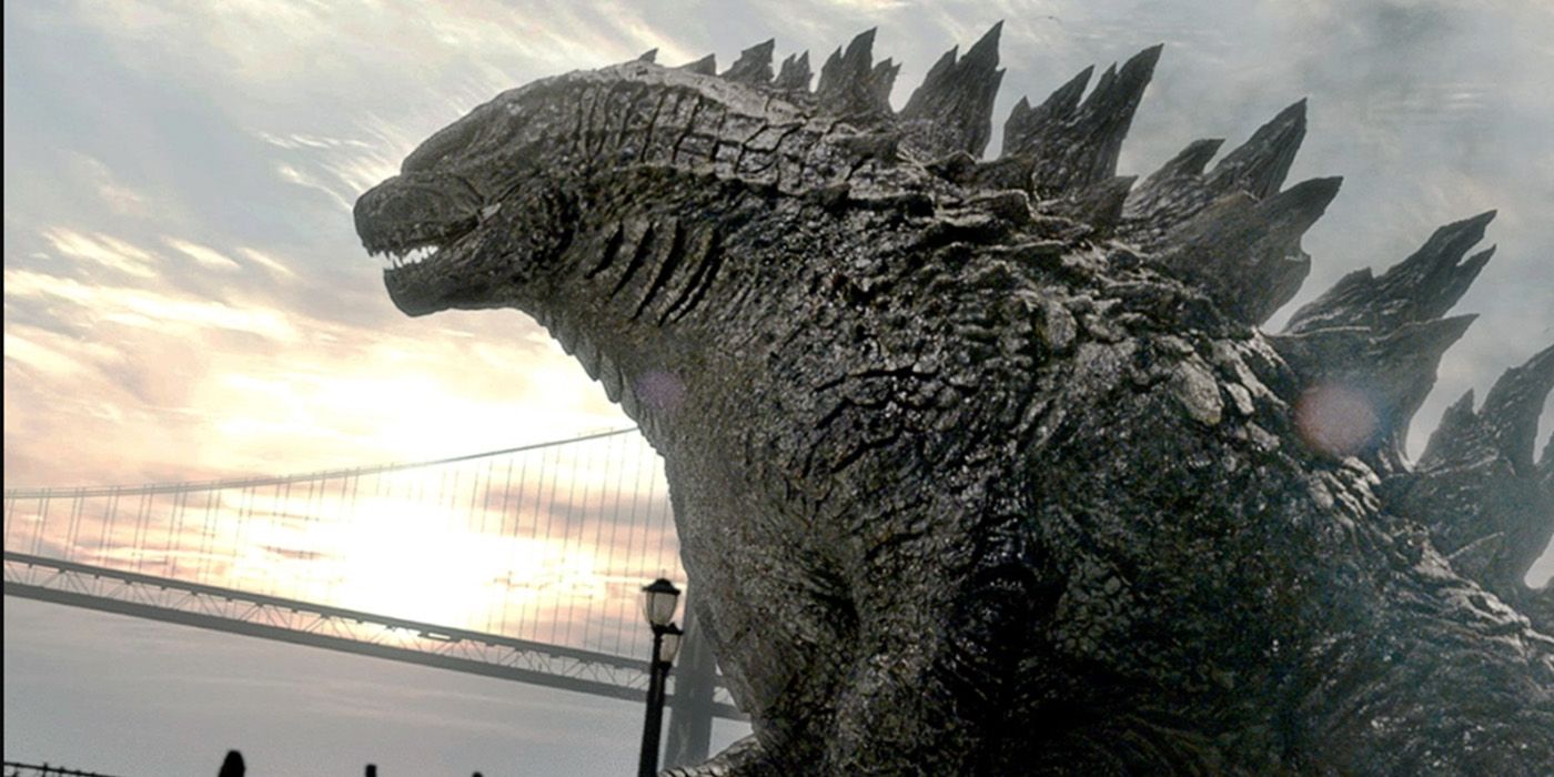 Godzilla walking near a large bridge over the ocean in the MonsterVerse movies