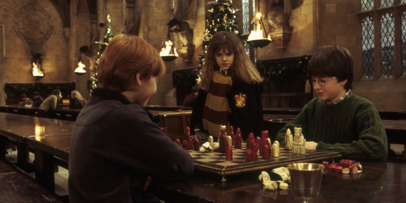 Harry and Ron play chess while hermione looks at them on the great hallway in Harry Potter and the Philosopher's stone