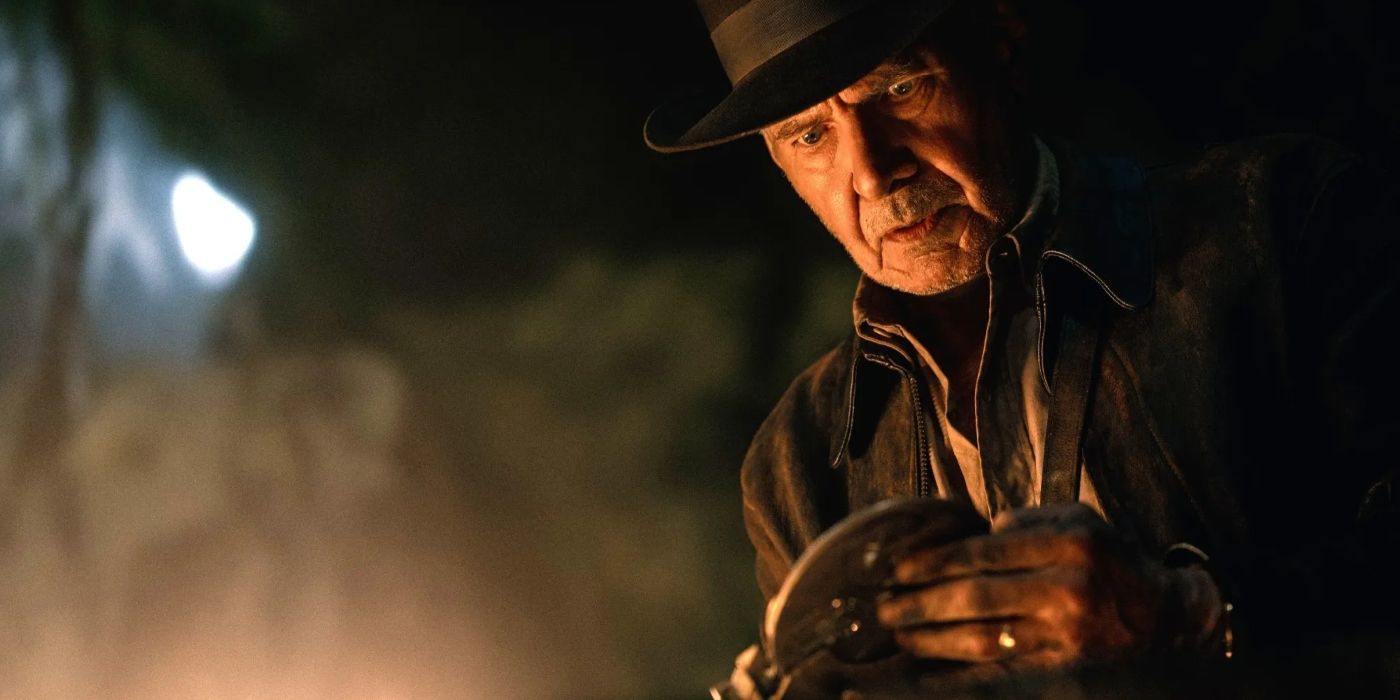 Indiana jones holds the dial of destiny in indiana jones and the dial of destiny